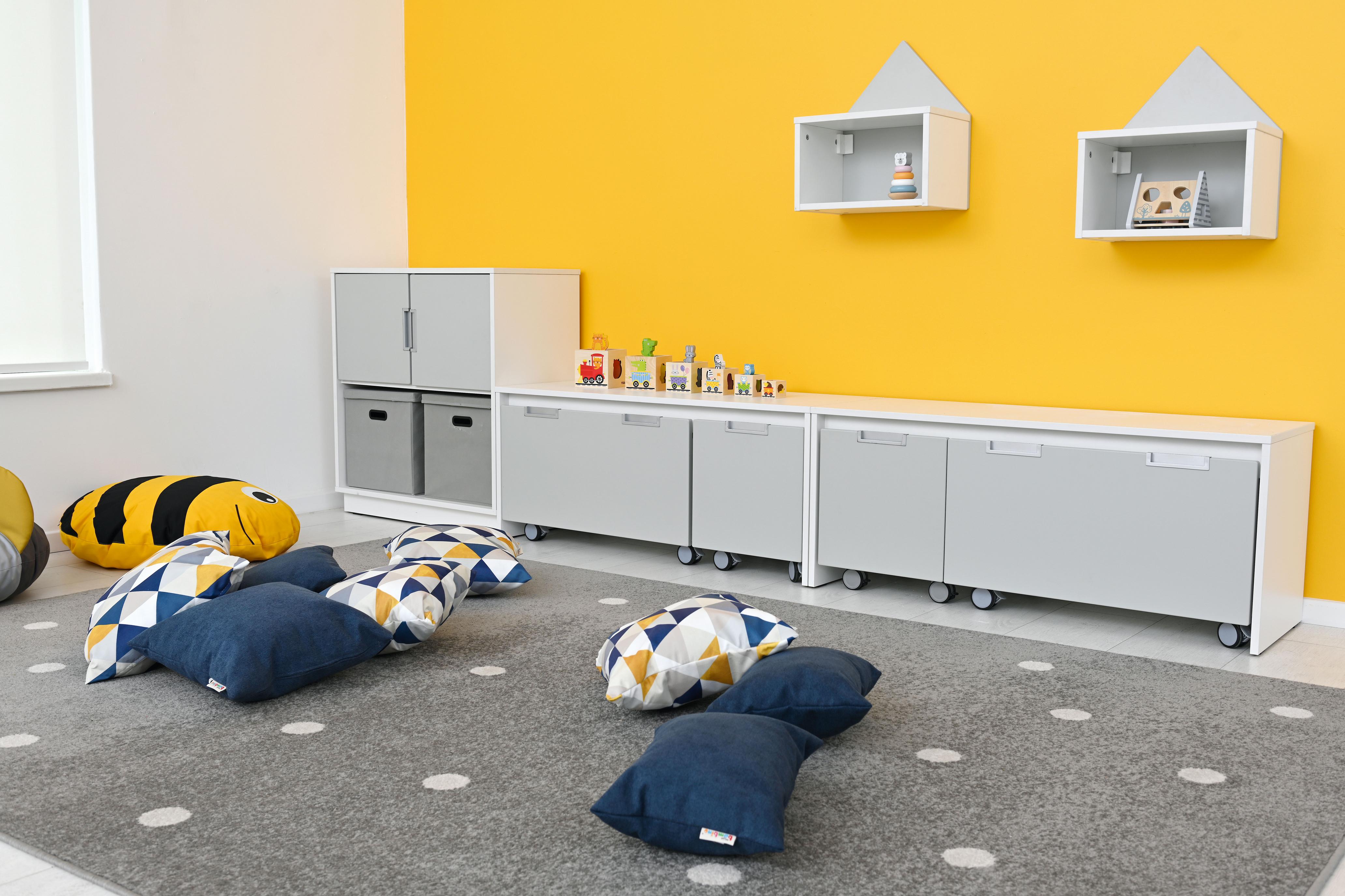 Kissen für Sitzlandschaft im farbenfrohen Gruppenraum arrangiert.