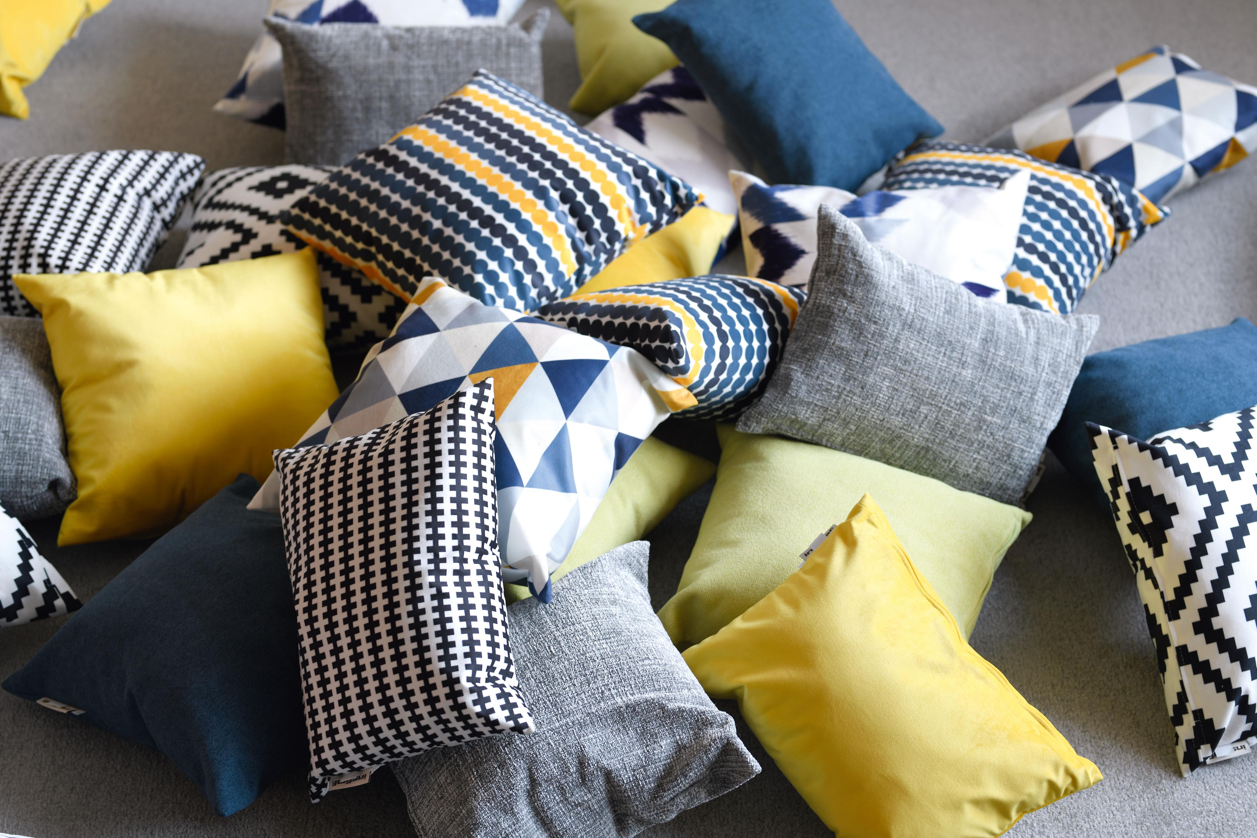 Bunte Kissen für Sitzlandschaft in Gruppenraum verteilt.