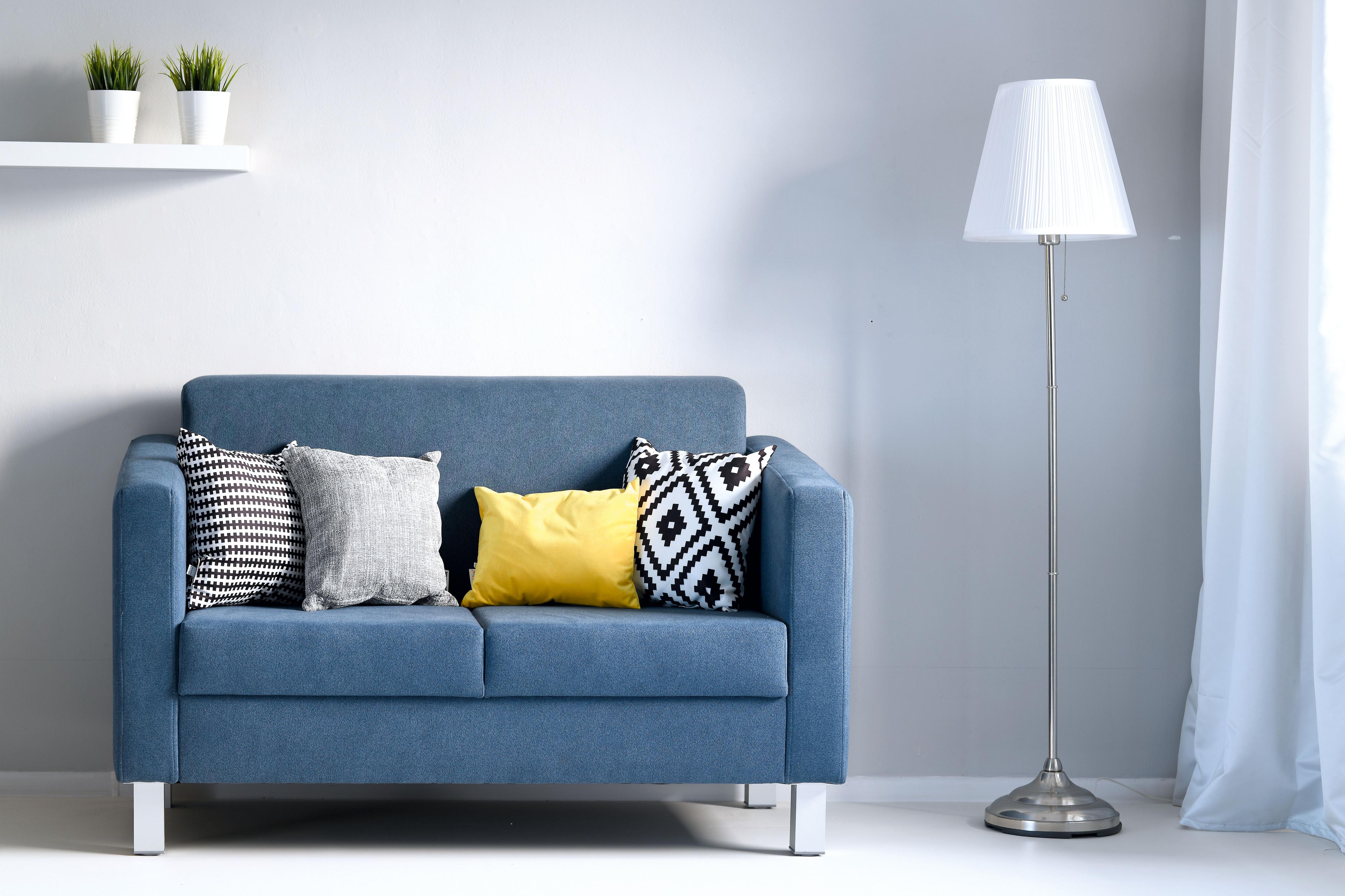 Kissen für Sitzlandschaft auf blauer Couch, gelb betont.
