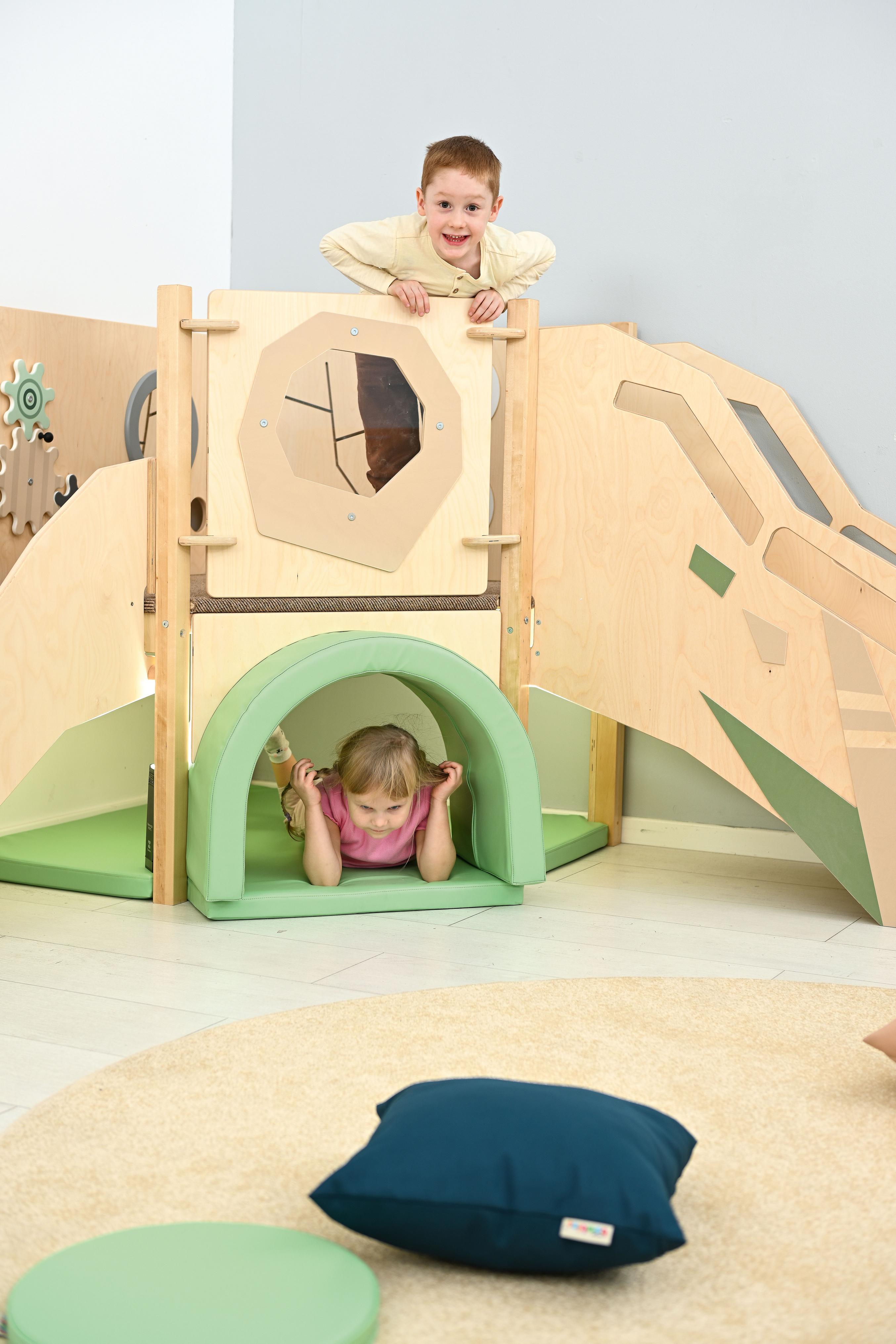 Kinder spielen in sensorischer Spielecke auf Hochebene.