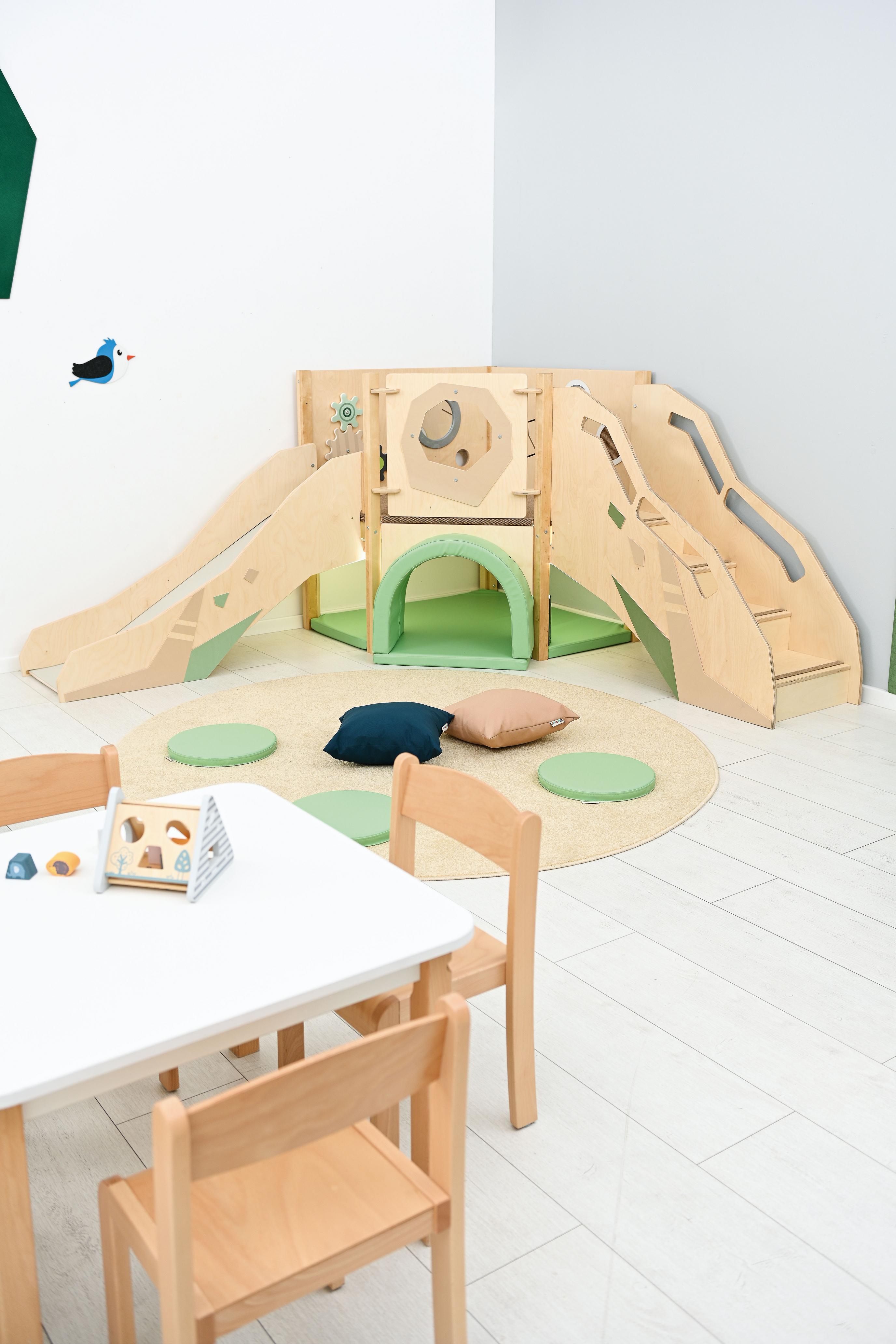 Sensorische Hochebene mit Rutsche und Spieltunnel im Raum.