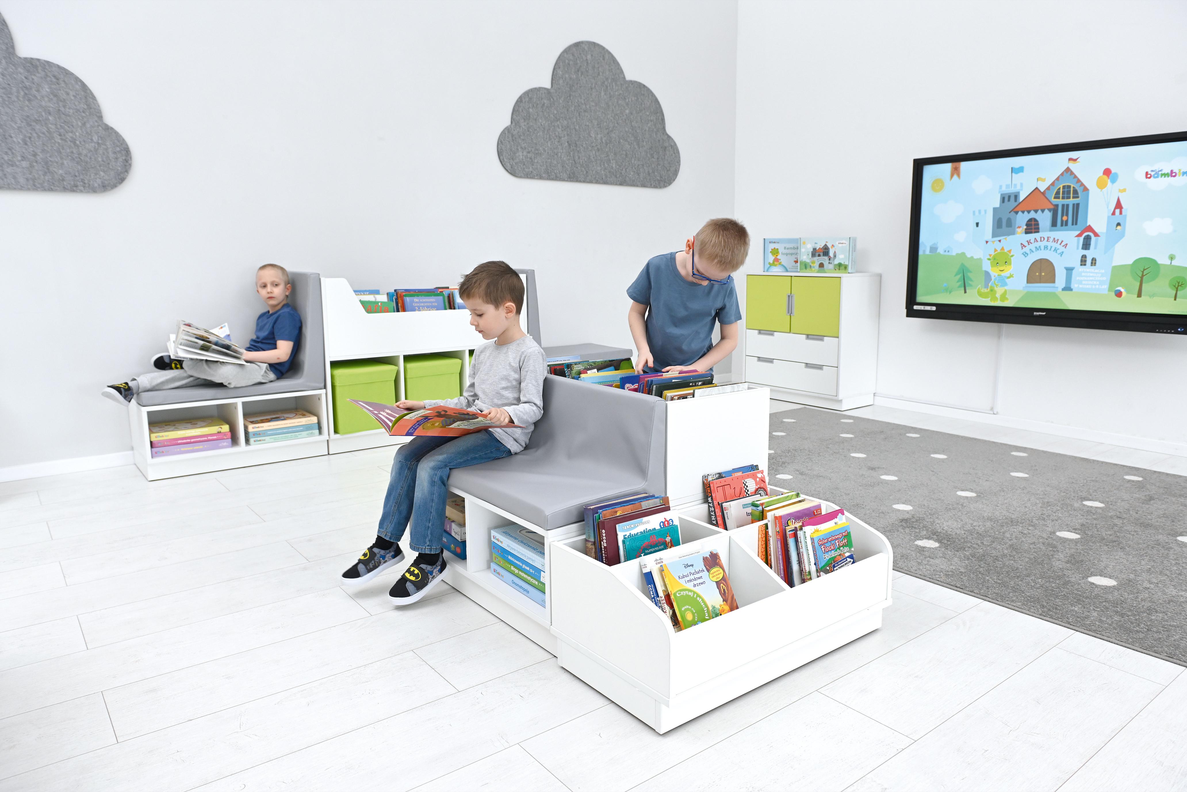 Kinder lesen auf einer weißen Bücherbank in Leseecke. - Produkt wird im Kindergarten oder Schule genutzt.