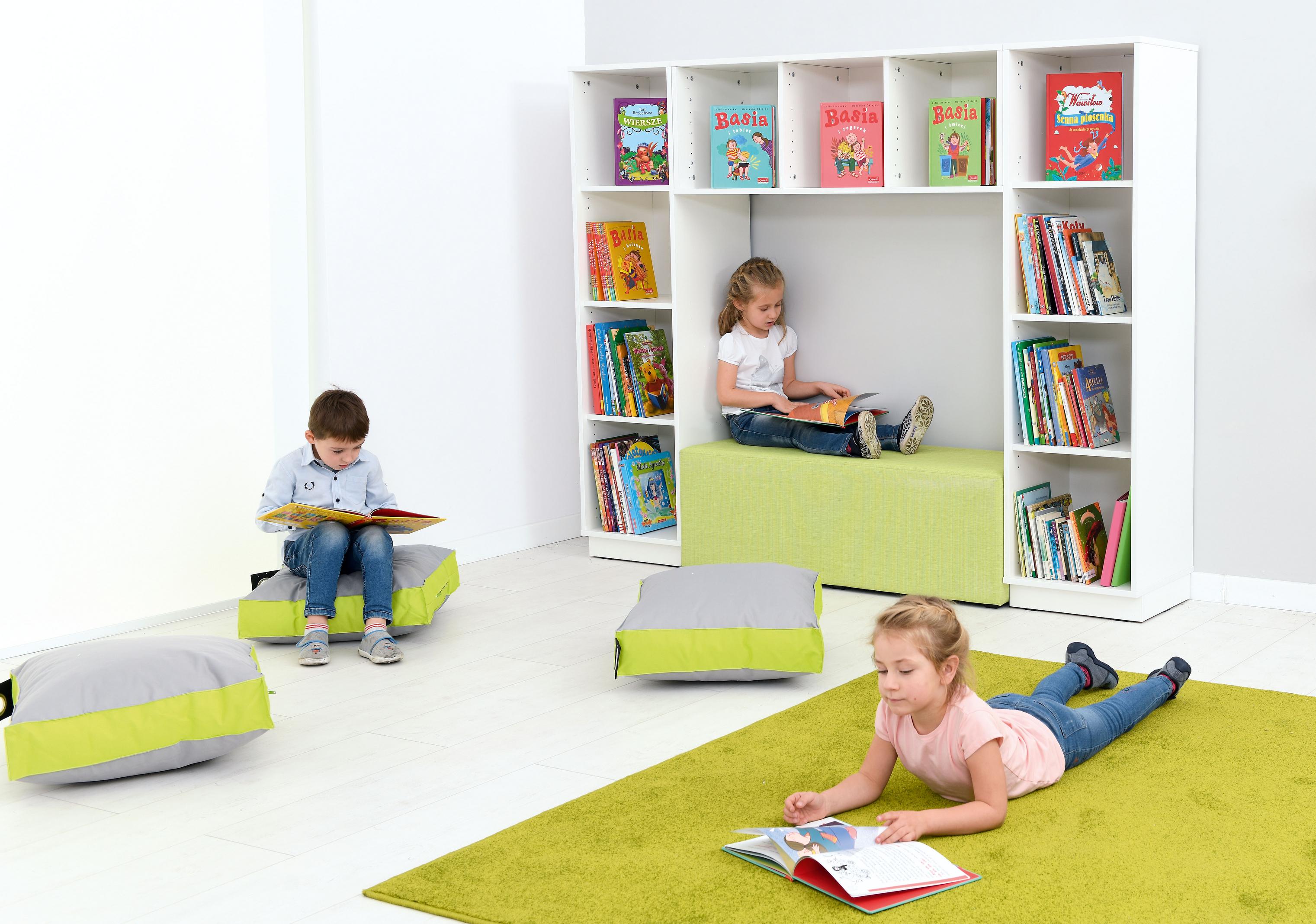 Kinder lesen gemütlich in der Bücherecke mit Bücherregal. - Produkt wird im Kindergarten oder Schule genutzt.