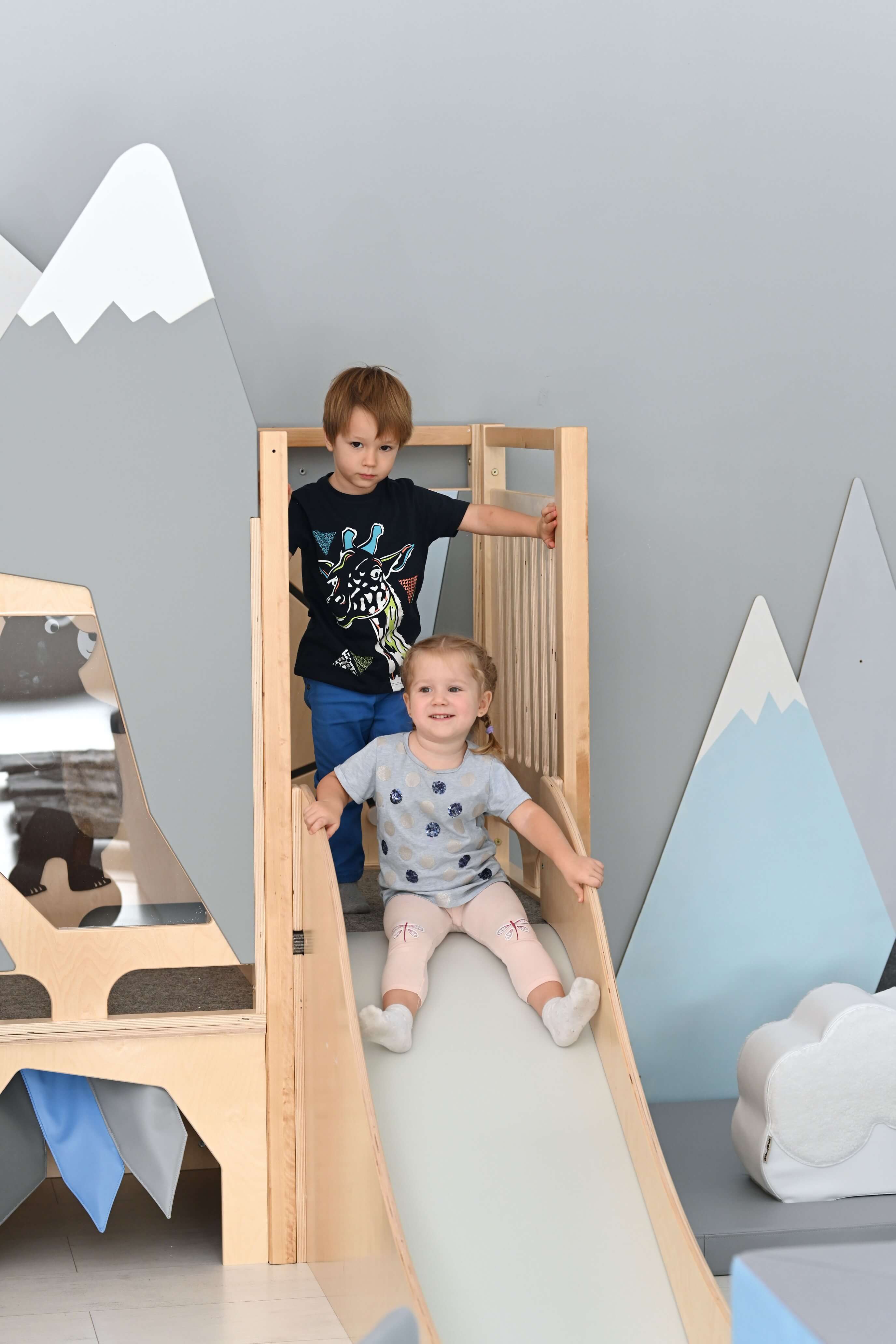 Kindergarten Spielpodest Alpenblick im Gruppenraum Kinder spielen auf Rutsche