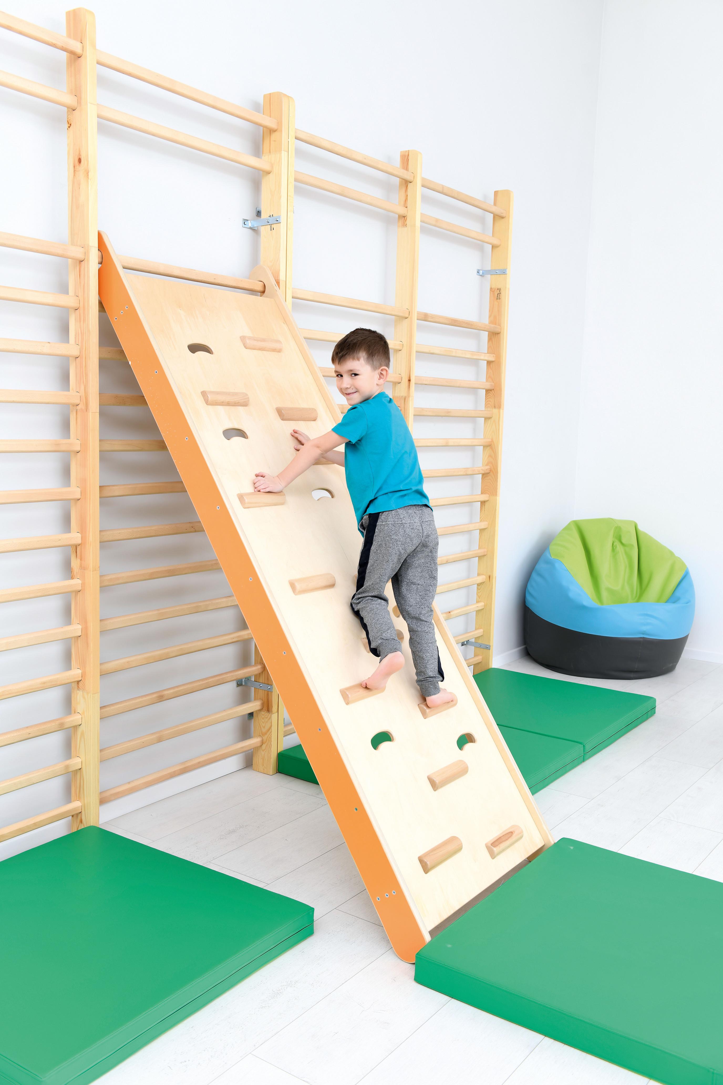 Kletterwand in Kita: Kind klettert sicher im Gruppenraum.