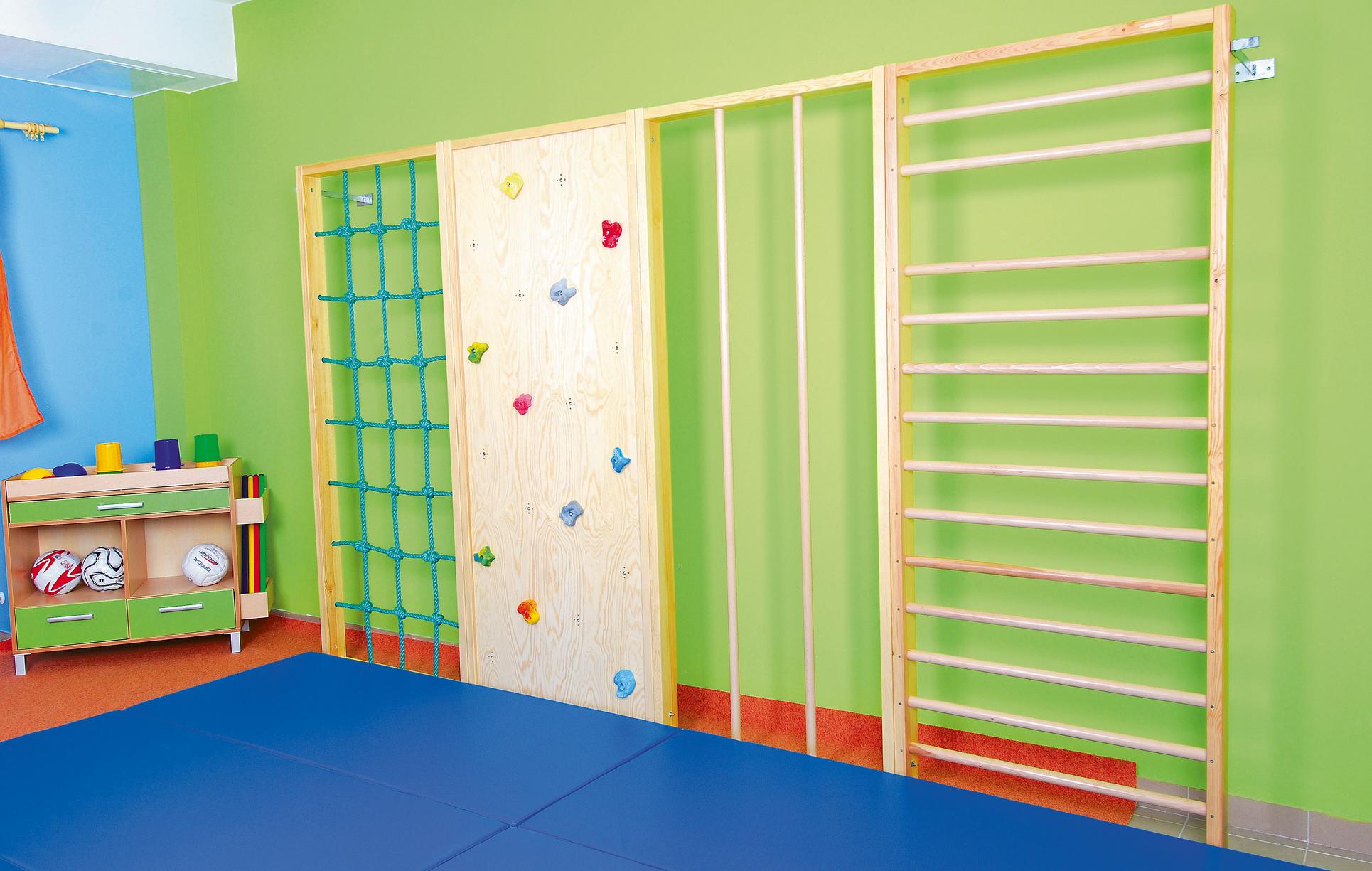 Kletterwand in Turnhalle mit Sprossen und Klettergriffen.