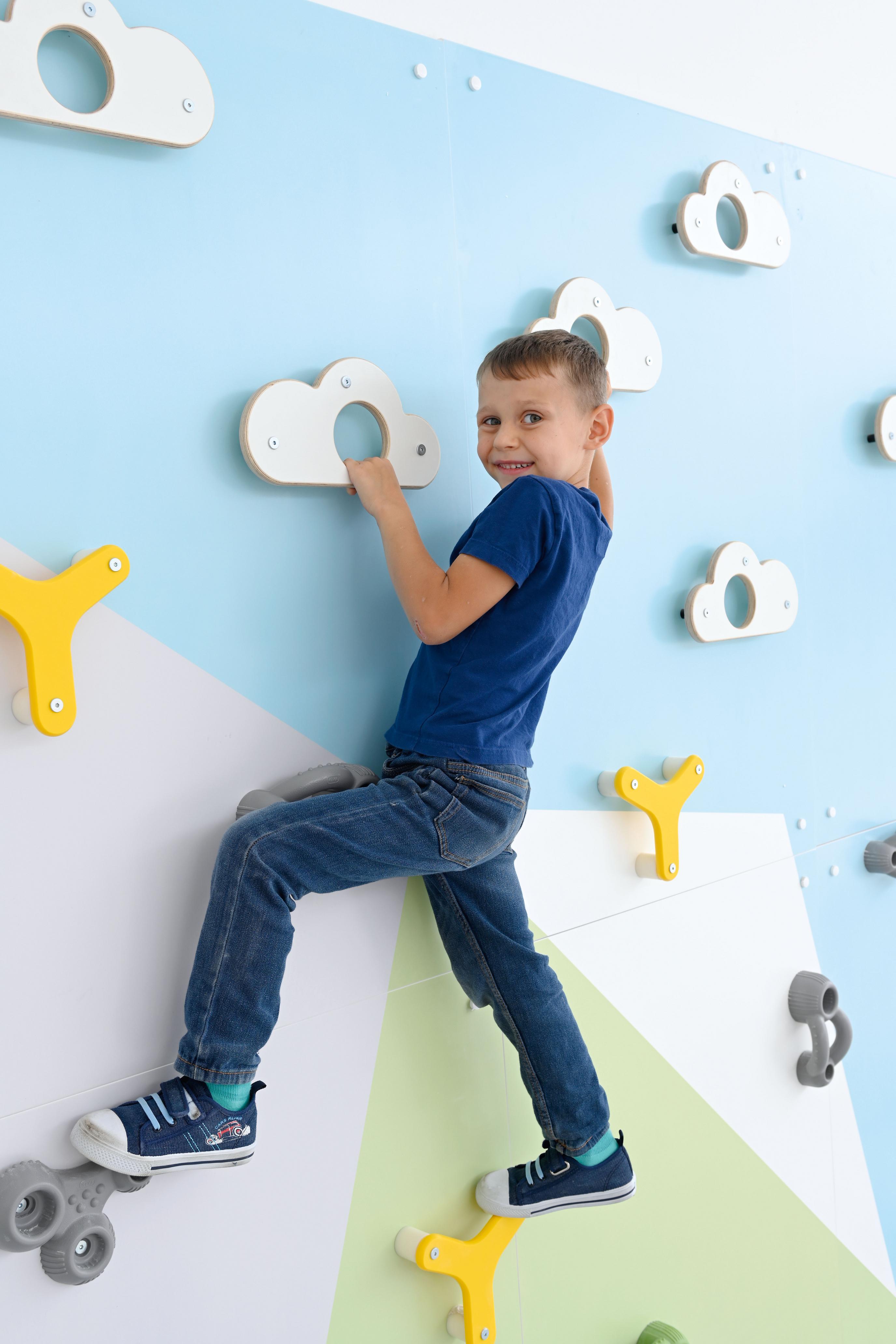 Kletterwand mit kindgerechten Griffen in Sporthalle.