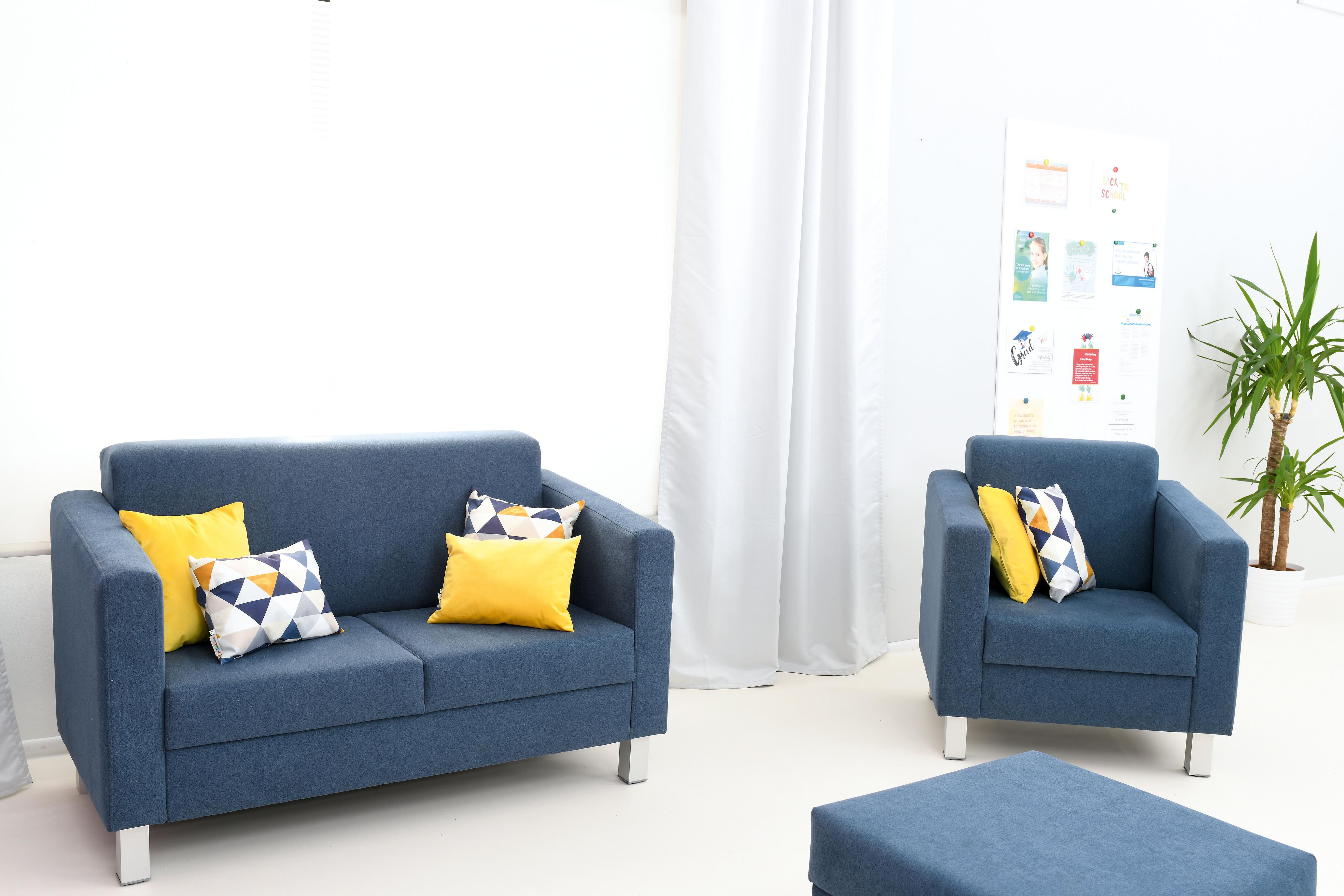 Kissen für Sitzlandschaft auf blauen Sesseln und Sofa.