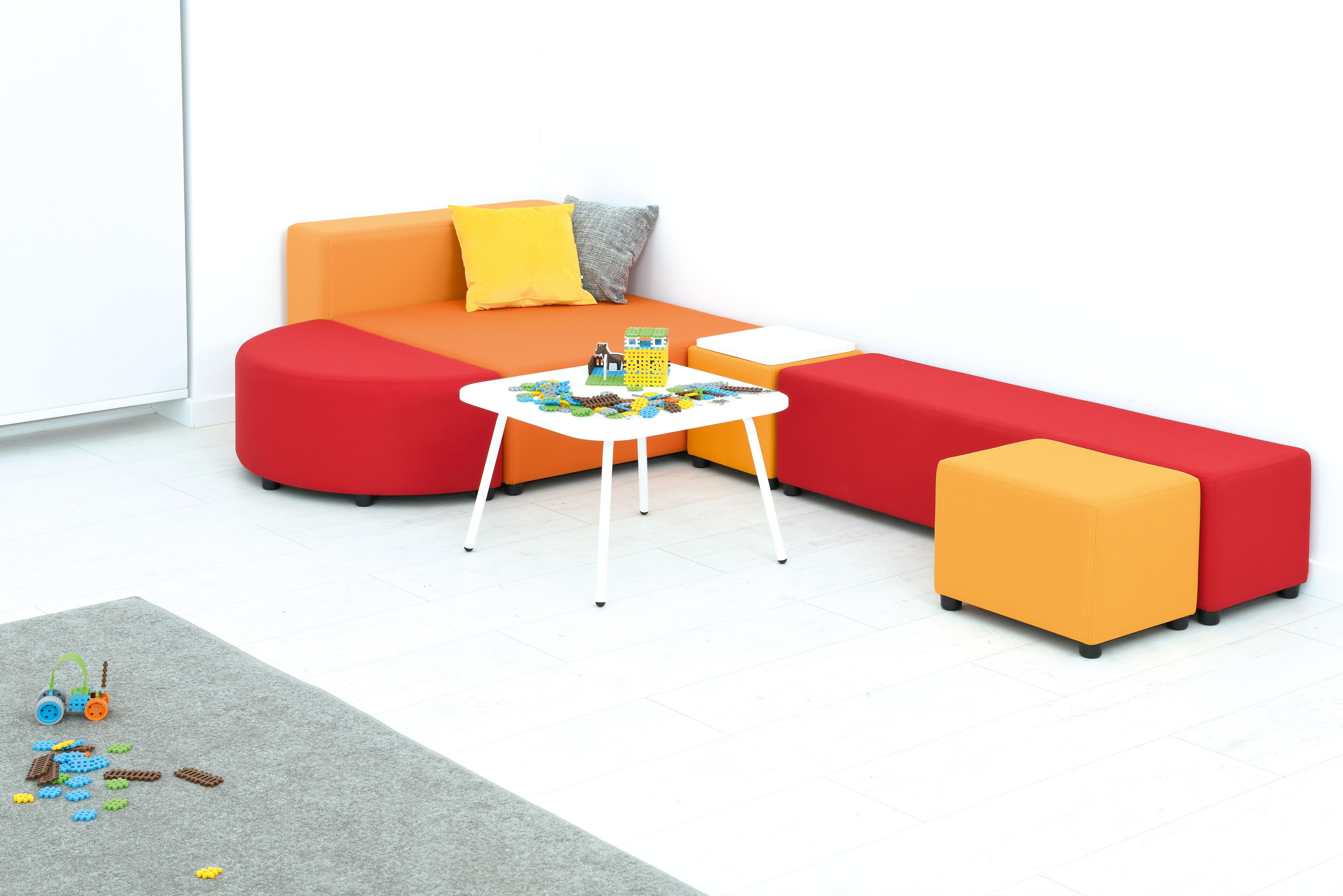 Bunte Sitzlandschaften mit Loungemöbeln im Gruppenraum.